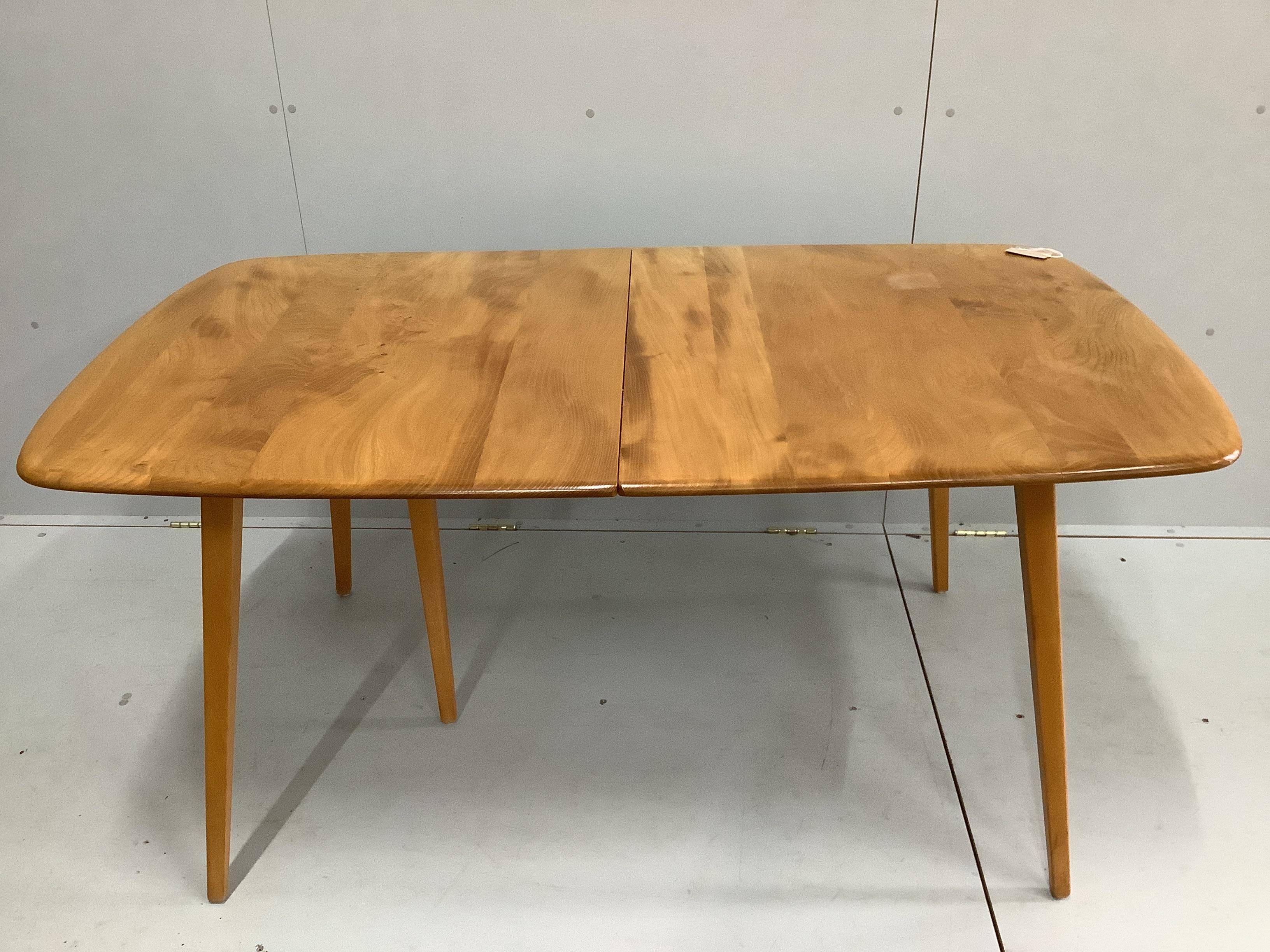 An Ercol elm and beech rectangular extending dining table, 224cm extended, width 88cm, height 71cm together with four Ercol elm and beech comb back dining chairs